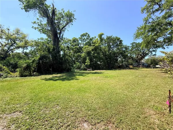 a view of green field with trees in the background