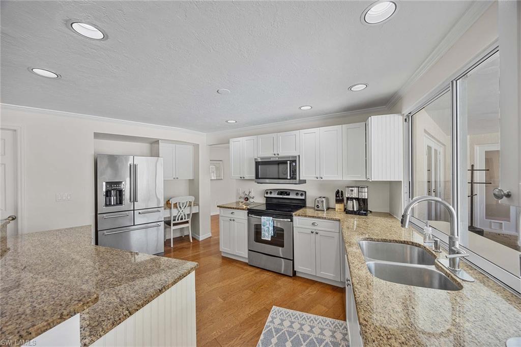 707 Portside Drive Naples, FL 34103 - Photo 13 of 35 a kitchen with stainless steel appliances granite countertop a sink stove and refrigerator