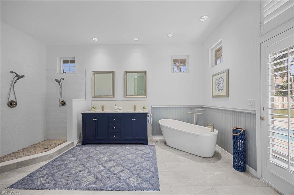 707 Portside Drive Naples, FL 34103 - Photo 18 of 35 a spacious bathroom with a tub sink and mirror