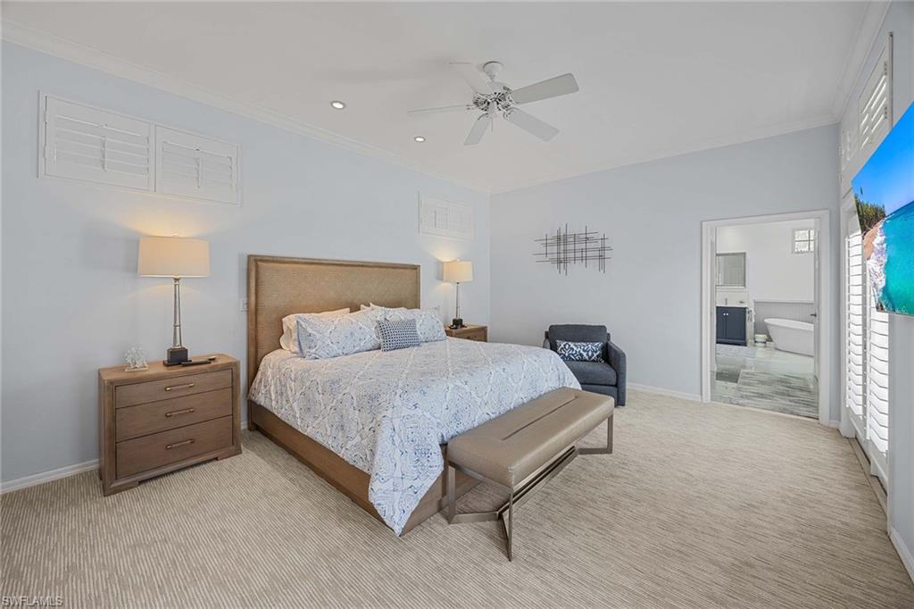 707 Portside Drive Naples, FL 34103 - Photo 19 of 35 a spacious bedroom with a bed and a lamp
