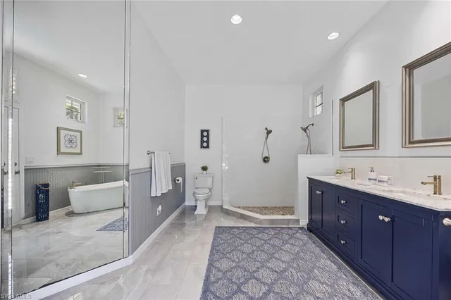 a spacious bathroom with a double vanity sink a large mirror and a bathtub