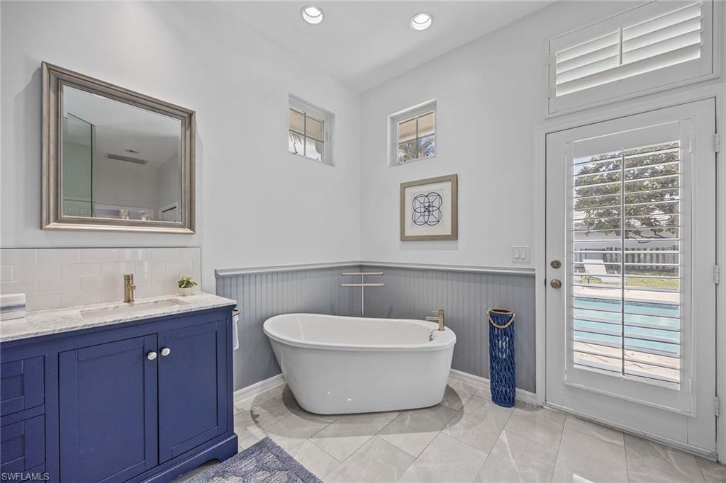 707 Portside Drive Naples, FL 34103 - Photo 23 of 35 a spacious bathroom with a toilet sink and mirror
