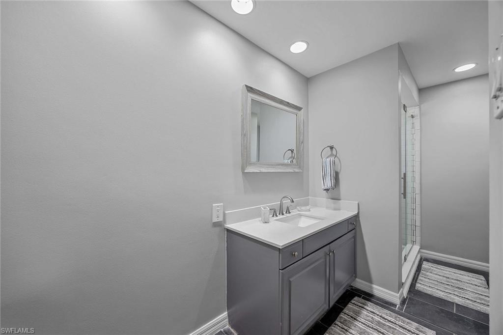 707 Portside Drive Naples, FL 34103 - Photo 29 of 35 a bathroom with a sink a mirror and vanity