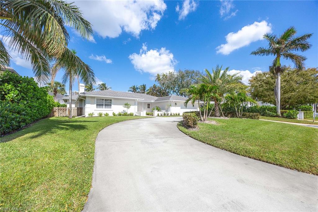 707 Portside Drive Naples, FL 34103 - Photo 3 of 35 a view of a house with a yard and a palm tree