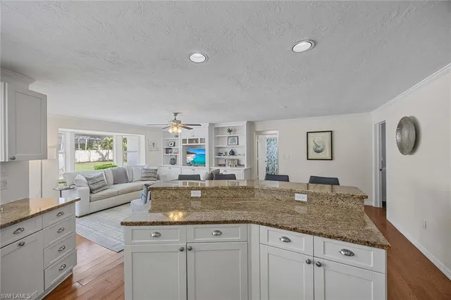 a kitchen with granite countertop a sink and white cabinets