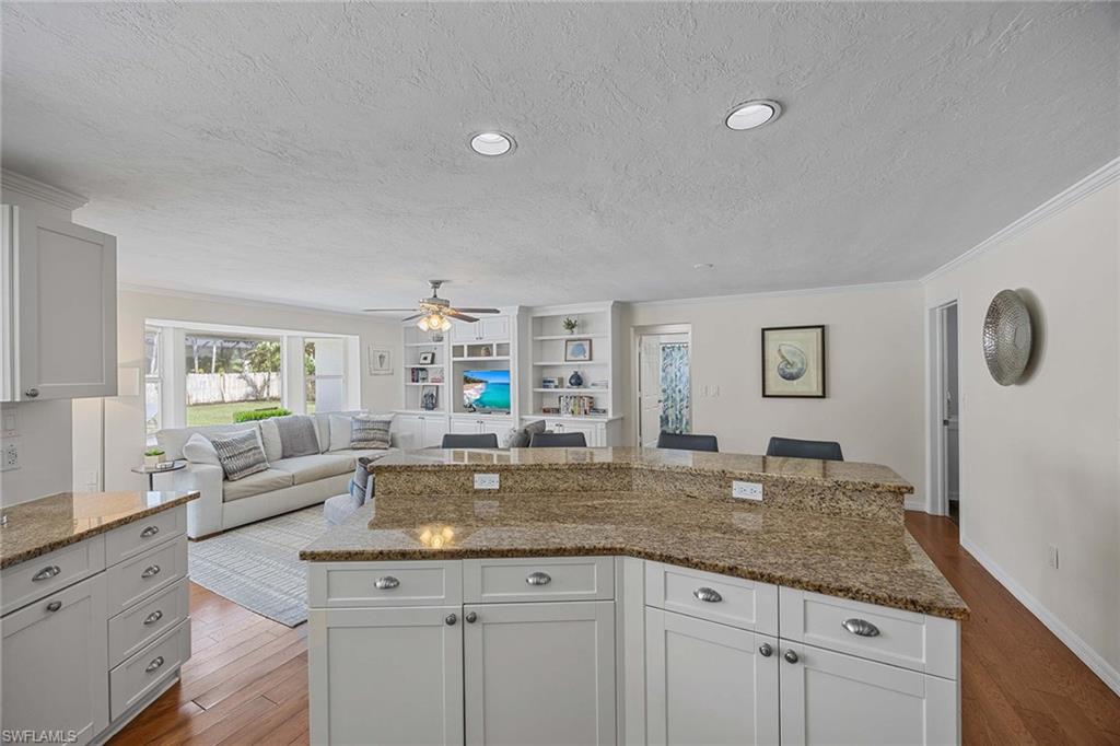 707 Portside Drive Naples, FL 34103 - Photo 10 of 35 a kitchen with granite countertop a sink and white cabinets