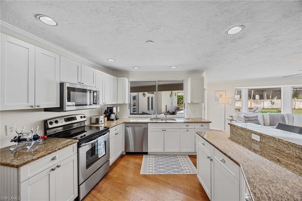 707 Portside Drive Naples, FL 34103 - Photo 10 of 35 a kitchen with stainless steel appliances granite countertop a sink and stove top oven