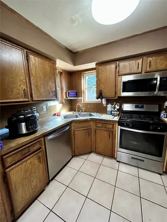 a kitchen with granite countertop a sink appliances cabinets and a counter top space