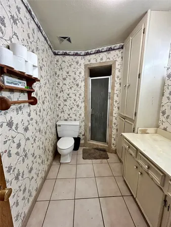a spacious bathroom with a granite countertop sink a toilet and a mirror
