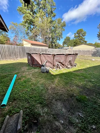 a view of a backyard with table and chairs potted plants and wooden fence