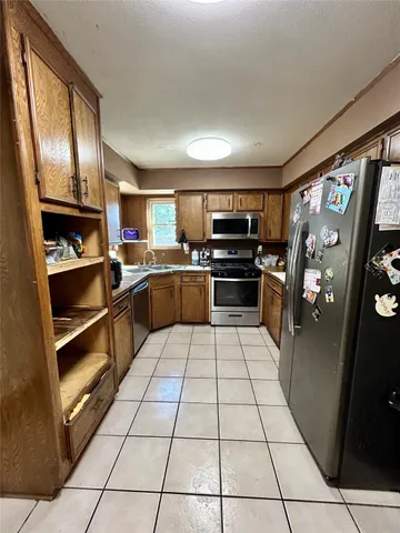 a kitchen with granite countertop a sink appliances cabinets and a counter top space