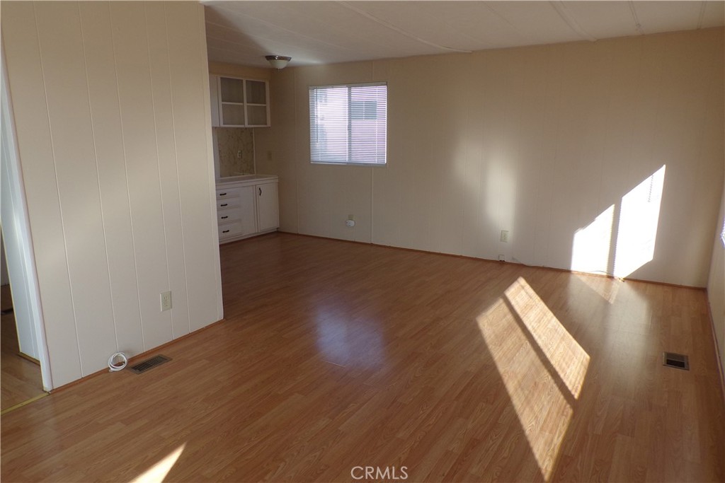 12710 3rd Street, Unit 32 Yucaipa, CA 92399 - Photo 6 of 14 an empty room with wooden floor and windows