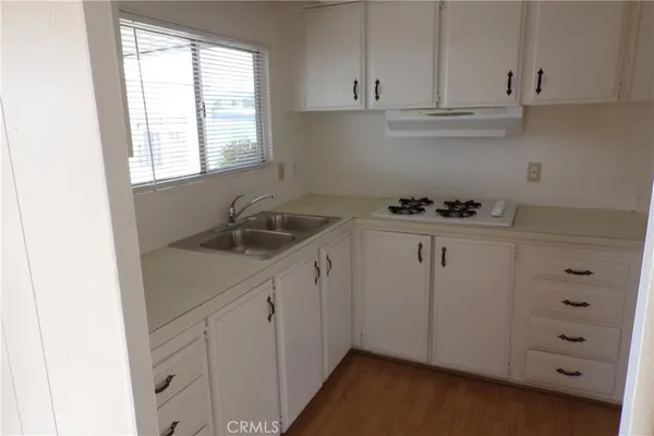 a kitchen with cabinets appliances a sink and a window
