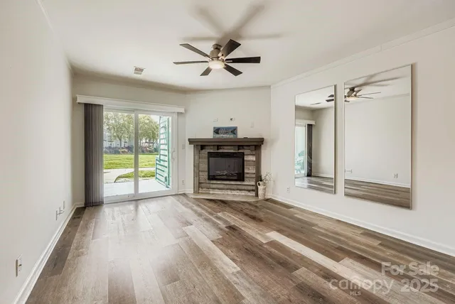 a view of an empty room with a fireplace and a window