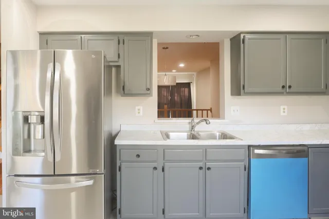 a view of an empty room with wooden floor fireplace and a window