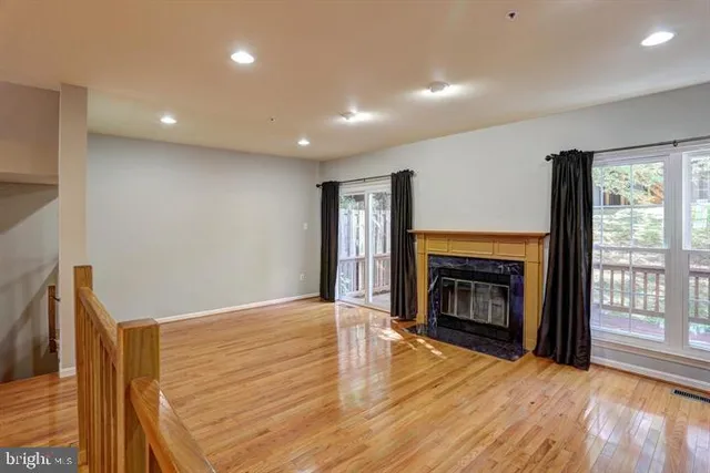 a view of an empty room with a fireplace and a window