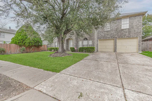 front view of a house with a yard and an trees