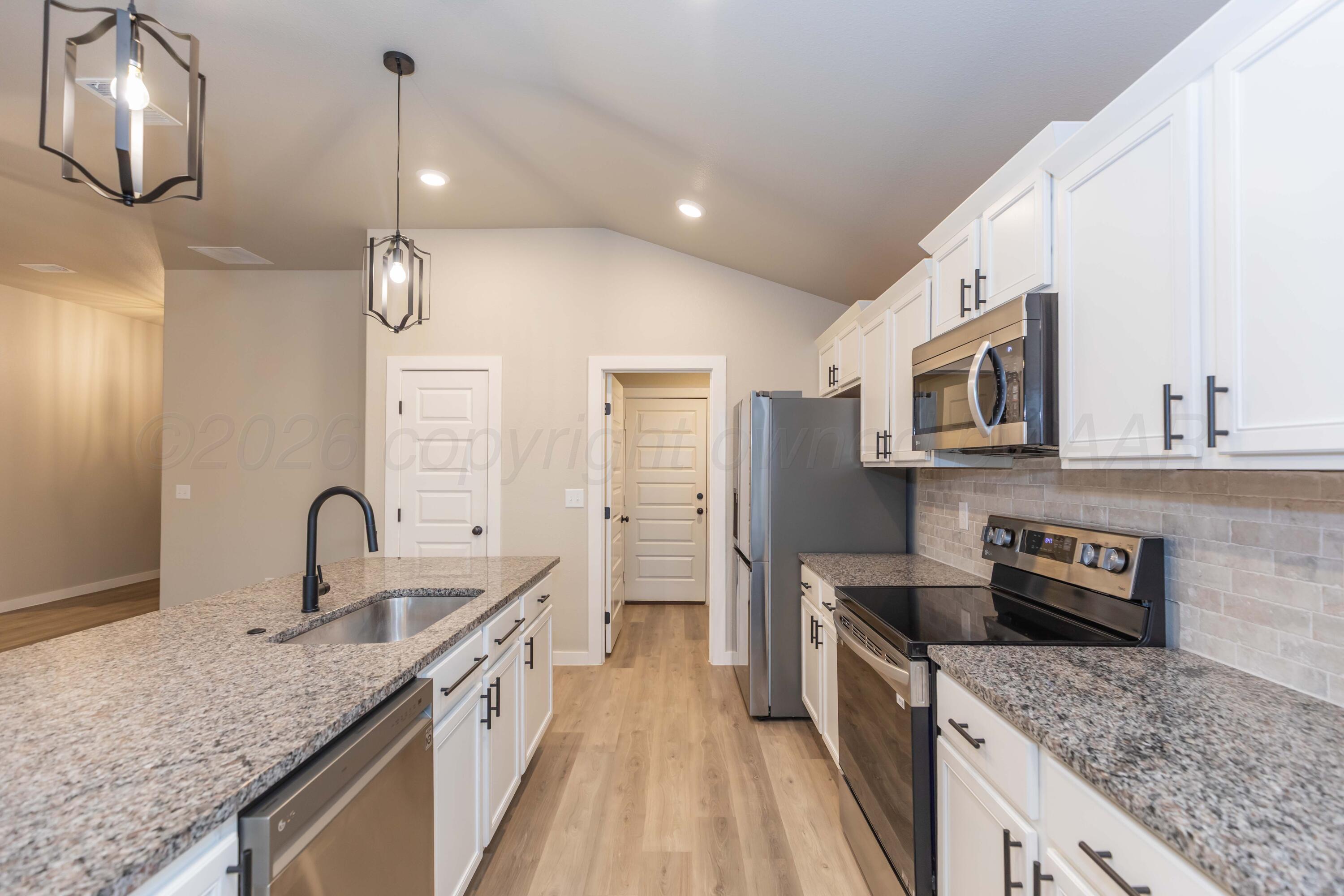 1807 Moon River Road Amarillo, TX 79118 - Photo 11 of 37 a large kitchen with stainless steel appliances granite countertop a sink stove and refrigerator