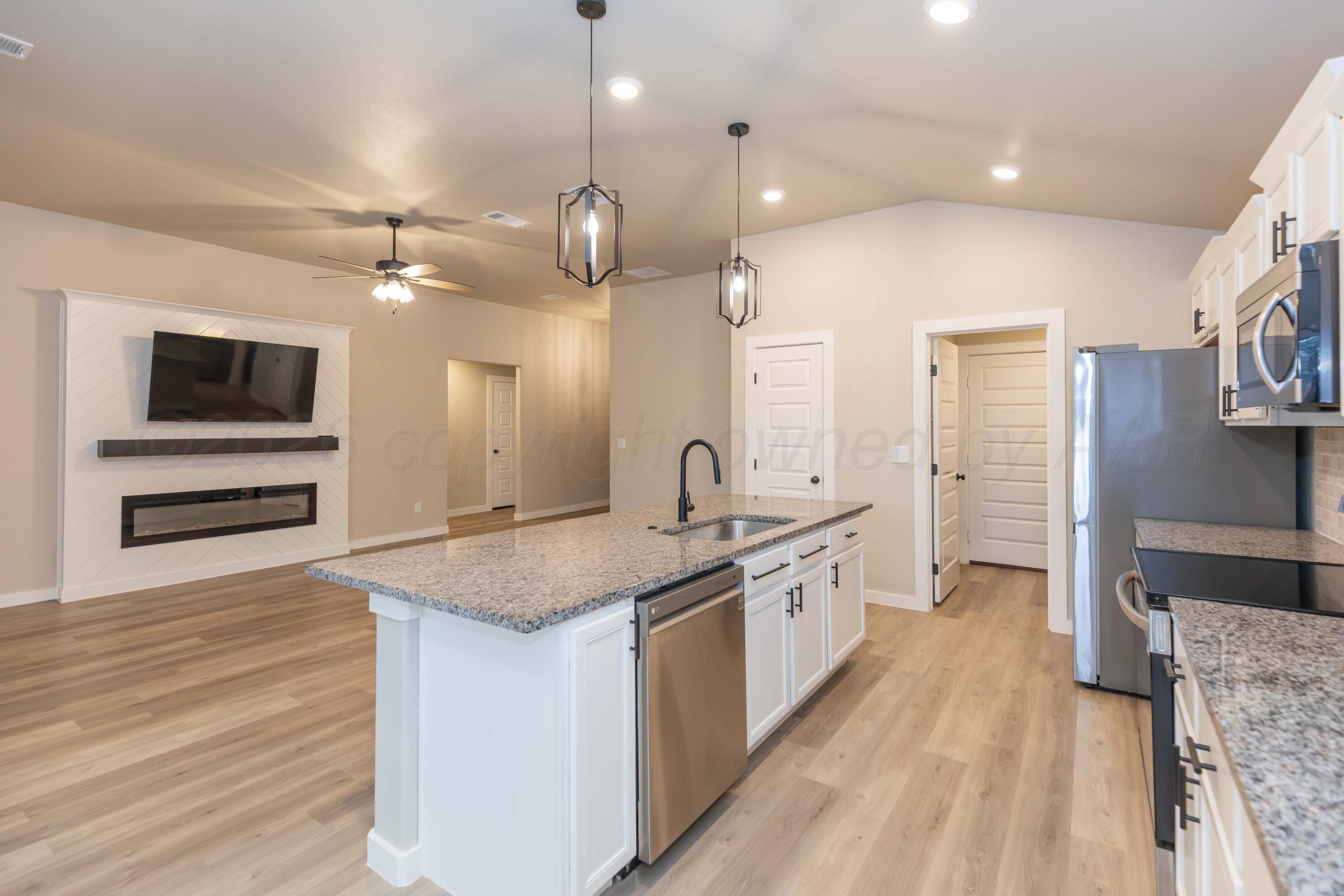 1807 Moon River Road Amarillo, TX 79118 - Photo 12 of 37 a large kitchen with stainless steel appliances a large center island a stove and a wooden floors