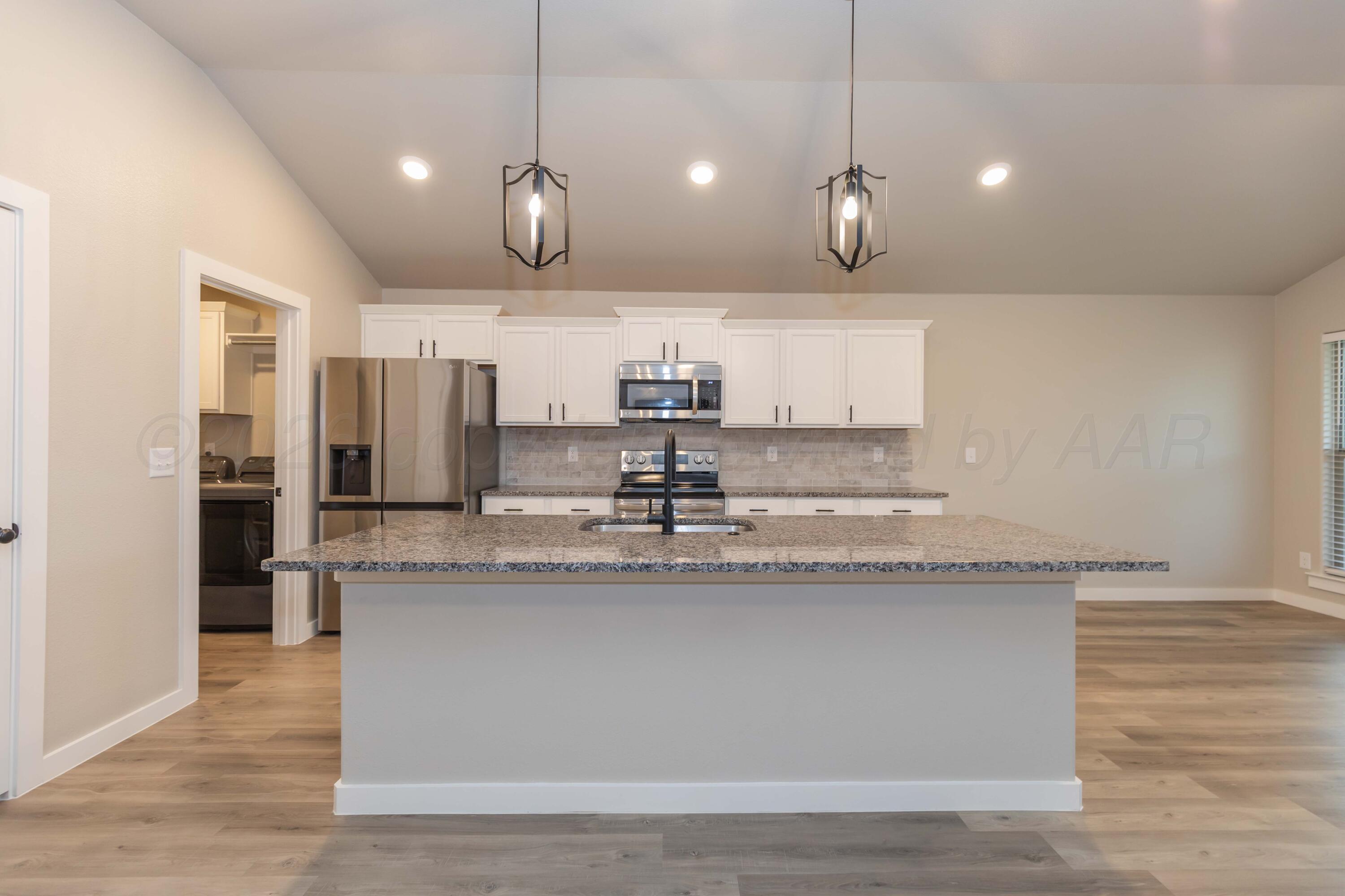 1807 Moon River Road Amarillo, TX 79118 - Photo 15 of 37 a large kitchen with granite countertop a sink a counter space appliances and cabinets