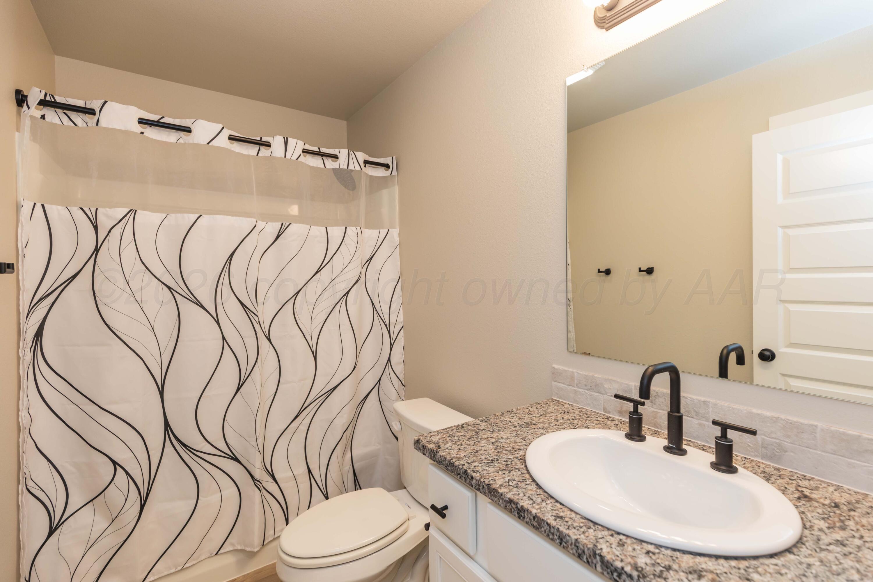 1807 Moon River Road Amarillo, TX 79118 - Photo 20 of 37 a bathroom with a granite countertop bathtub sink vanity mirror and toilet