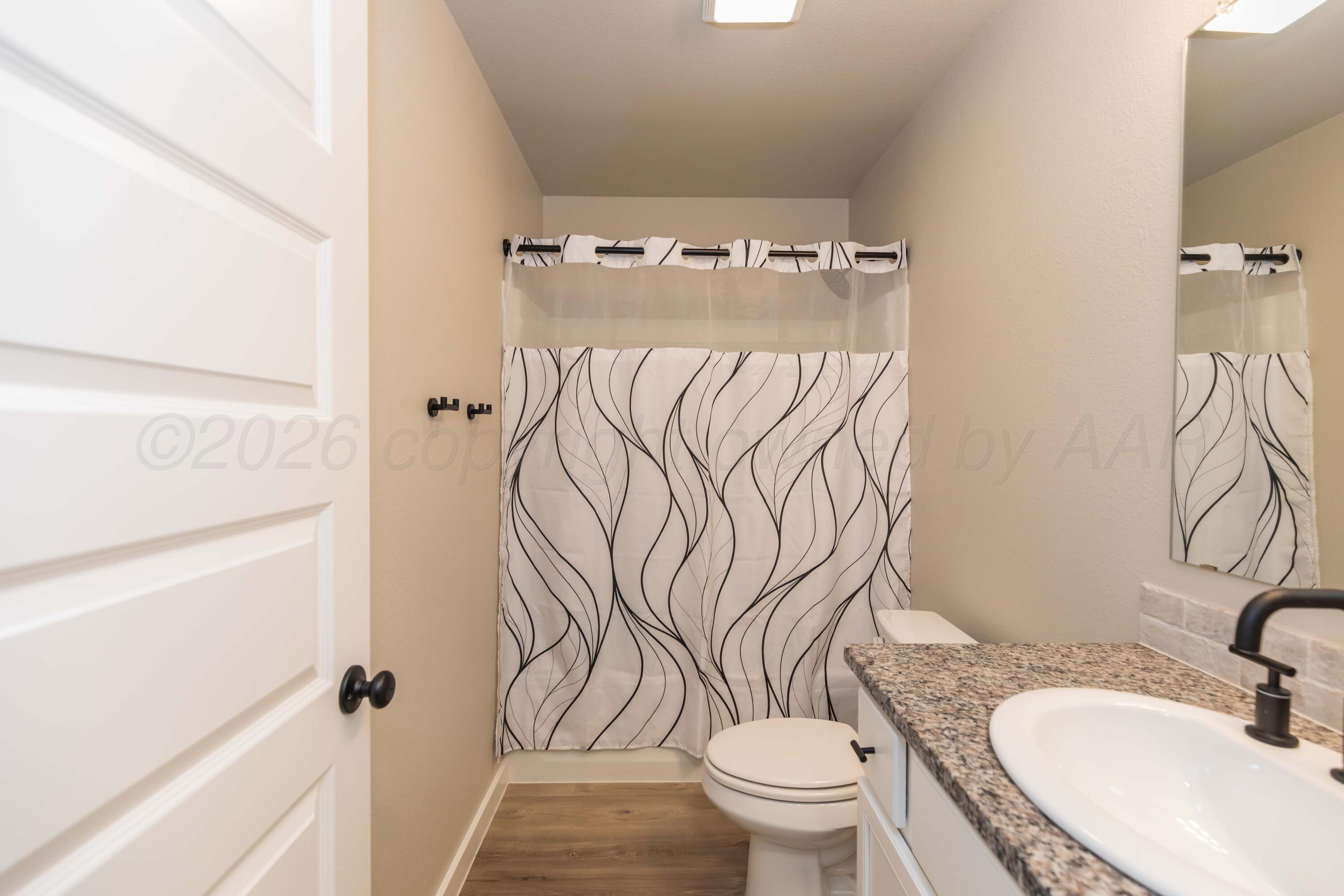 1807 Moon River Road Amarillo, TX 79118 - Photo 21 of 37 a bathroom with a toilet sink and mirror