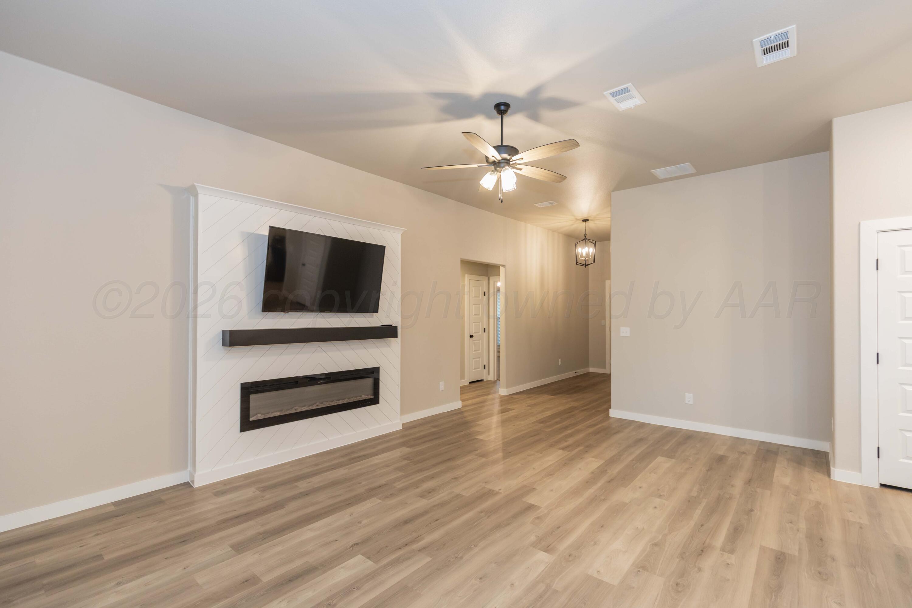 1807 Moon River Road Amarillo, TX 79118 - Photo 6 of 37 wooden floor in an empty room with a window