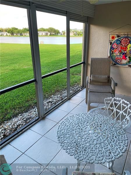Kings Point Delray Beach, FL 33484 - Photo 18 of 20 a living room with a floor to ceiling window and a table