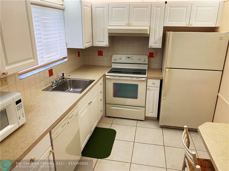 Kings Point Delray Beach, FL 33484 - Photo 7 of 20 a kitchen with a sink a stove and refrigerator