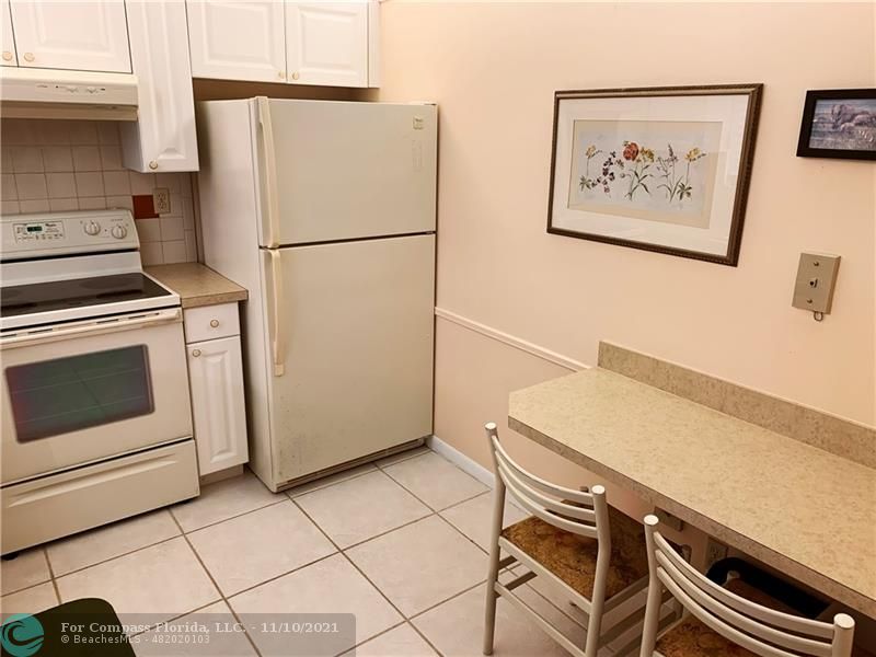 Kings Point Delray Beach, FL 33484 - Photo 8 of 20 a white refrigerator freezer and a stove sitting inside of a kitchen
