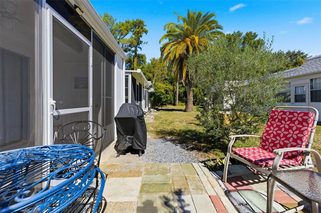 4218 Terrapin Place, Unit D New Port Richey, FL 34652 - Photo 30 of 34 a backyard of a house with barbeque oven table and chairs