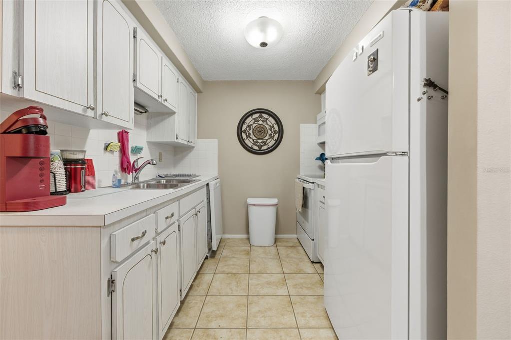 4218 Terrapin Place, Unit D New Port Richey, FL 34652 - Photo 9 of 34 a kitchen with a refrigerator and a sink