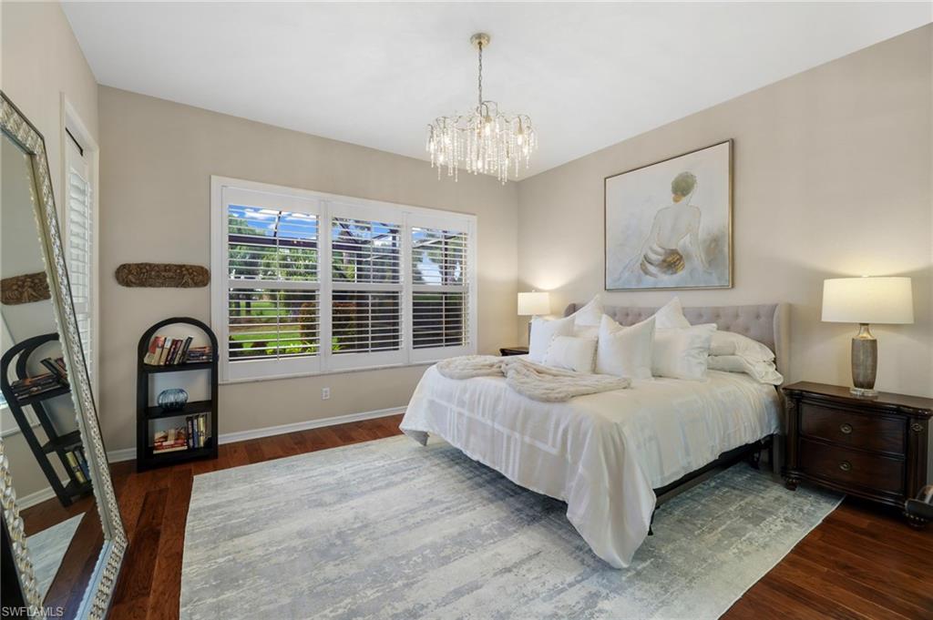 10071 St Moritz Drive Miromar Lakes, FL 33913 - Photo 12 of 45 a spacious bedroom with a bed a bookshelf and a large window