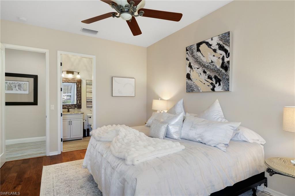 10071 St Moritz Drive Miromar Lakes, FL 33913 - Photo 17 of 45 a bedroom with a large bed and a chandelier