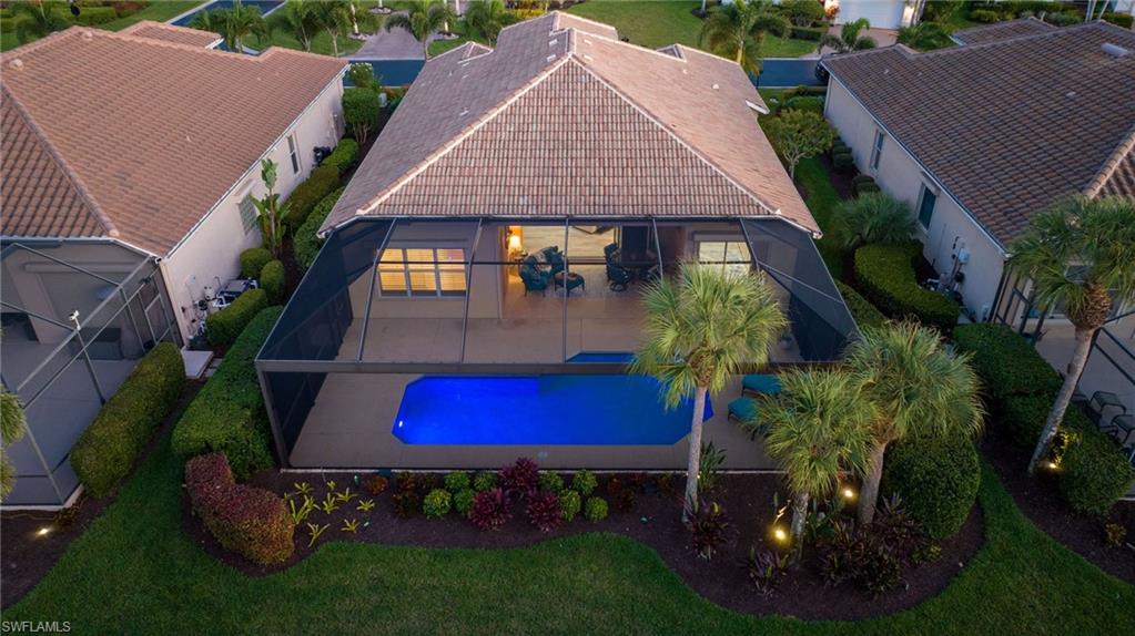 10071 St Moritz Drive Miromar Lakes, FL 33913 - Photo 25 of 45 a aerial view of a house with a yard plants and large tree