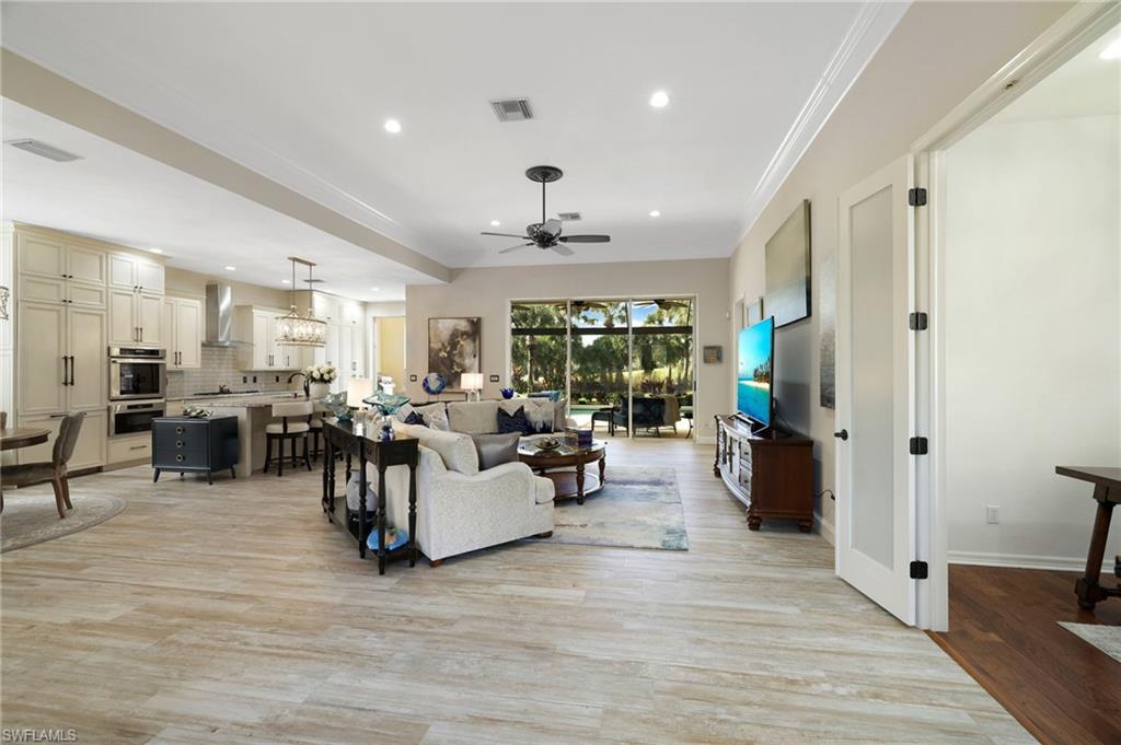 10071 St Moritz Drive Miromar Lakes, FL 33913 - Photo 5 of 45 a living room with couches and kitchen view with wooden floor