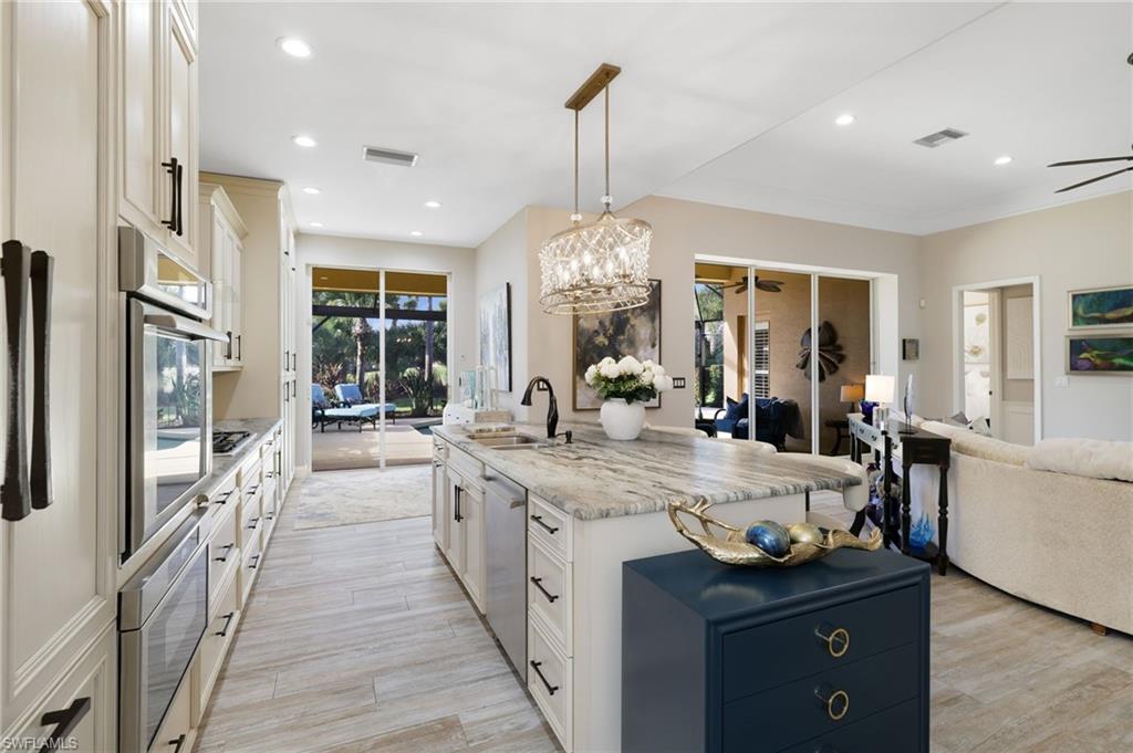 10071 St Moritz Drive Miromar Lakes, FL 33913 - Photo 9 of 45 a large kitchen with stainless steel appliances granite countertop a lot of counter space and wooden floor