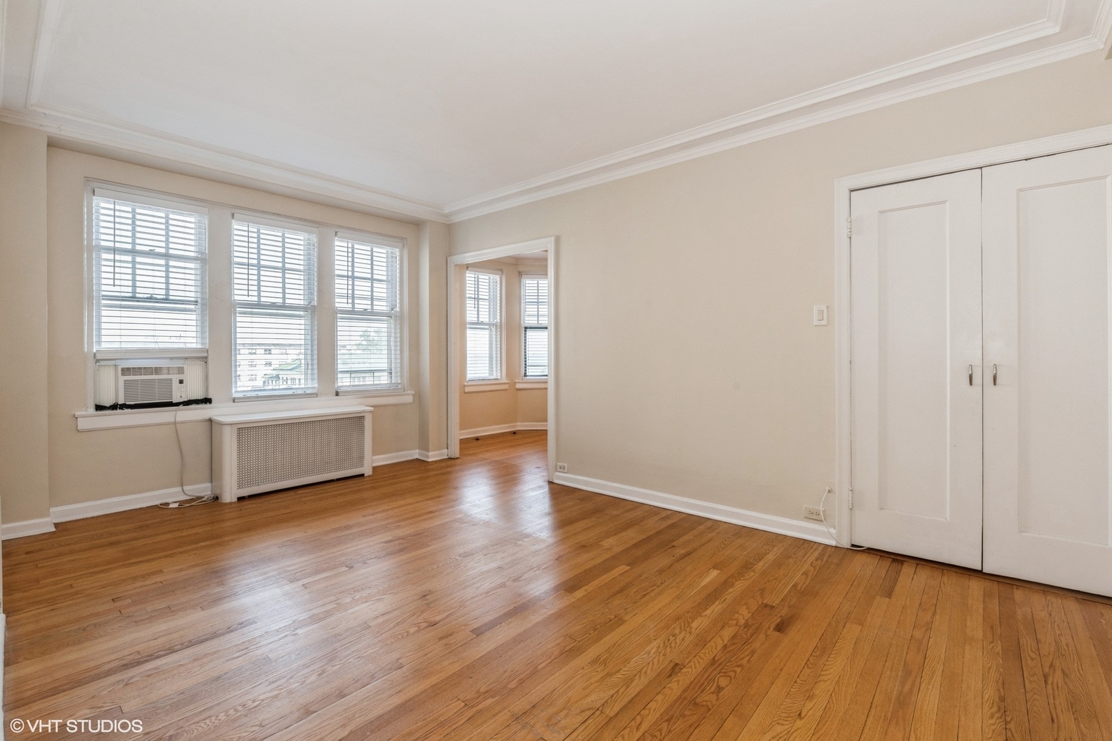 6334 North Sheridan Road, Unit 4C Chicago, IL 60660 - Photo 6 of 13 an empty room with wooden floor and windows