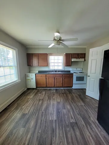 a kitchen with wooden floors and wooden cabinets