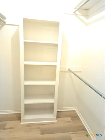 a view of walk in closet with empty racks