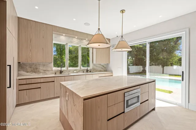 a kitchen with kitchen island a large counter top space and a view of living room