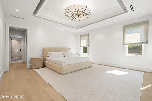 a spacious bedroom with a bed and a chandelier
