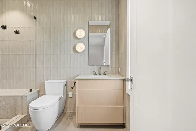 a bathroom with a granite countertop toilet a sink a shower and mirror