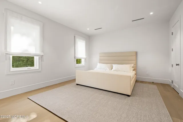 a white bed sitting in a room next to a window