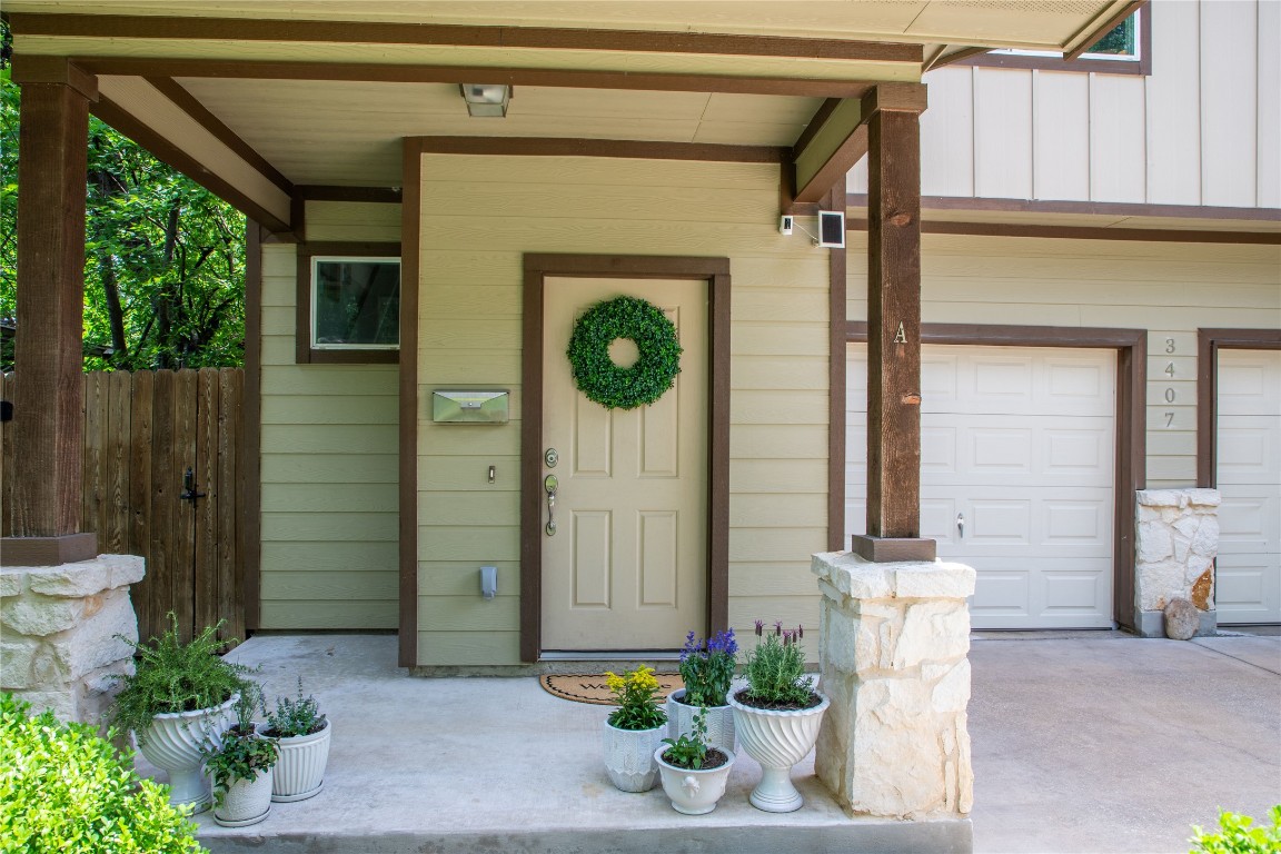 3407 Banton Road, Unit A Austin, TX 78722 - Photo 3 of 39 View of exterior entry with covered porch, a garage, and board and batten siding