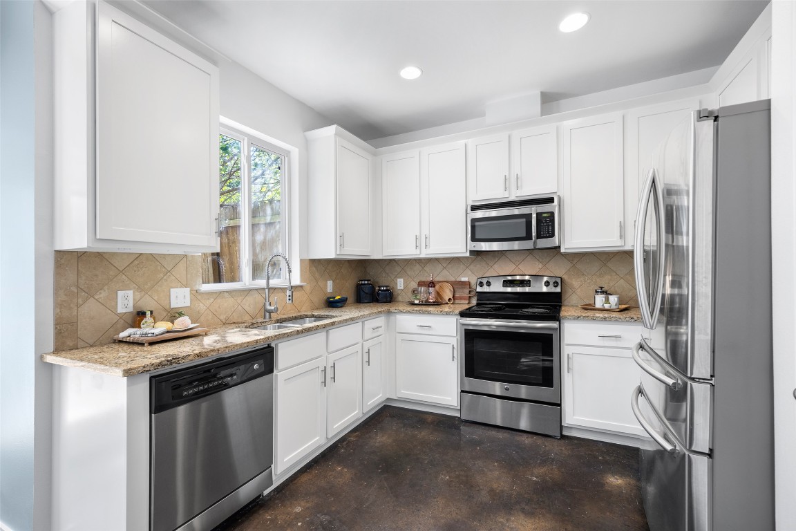 3407 Banton Road, Unit A Austin, TX 78722 - Photo 31 of 39 Kitchen featuring appliances with stainless steel finishes, white cabinetry, light stone counters, finished concrete floors, and recessed lighting