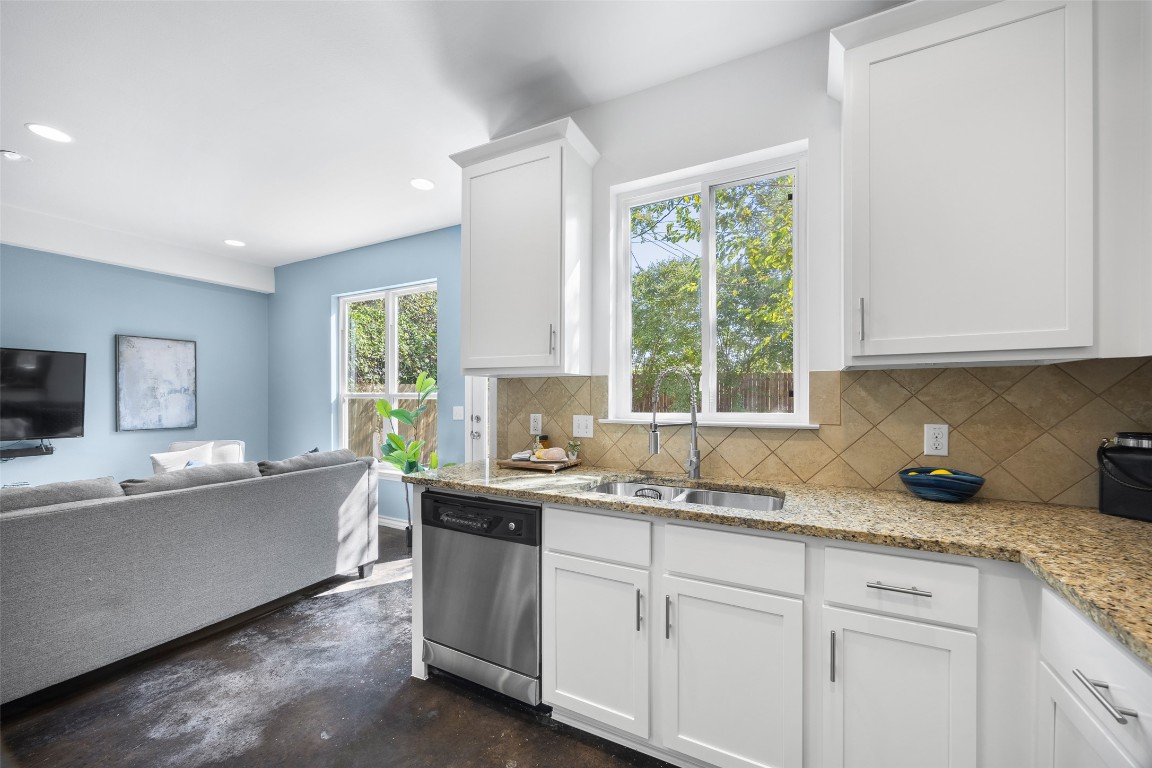 3407 Banton Road, Unit A Austin, TX 78722 - Photo 39 of 39 Kitchen featuring finished concrete floors, white cabinetry, stainless steel dishwasher, decorative backsplash, and open floor plan