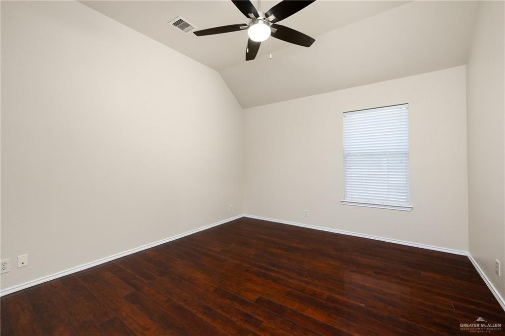 3400 San Angelo Street Mission, TX 78572 - Photo 9 of 12 an empty room with wooden floor fan and windows