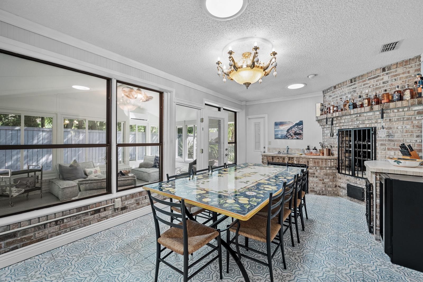3911 Hillwood Road Jacksonville, FL 32223 - Photo 21 of 33 Tiled dining space with a textured ceiling, a chandelier, a healthy amount of sunlight, and a brick fireplace