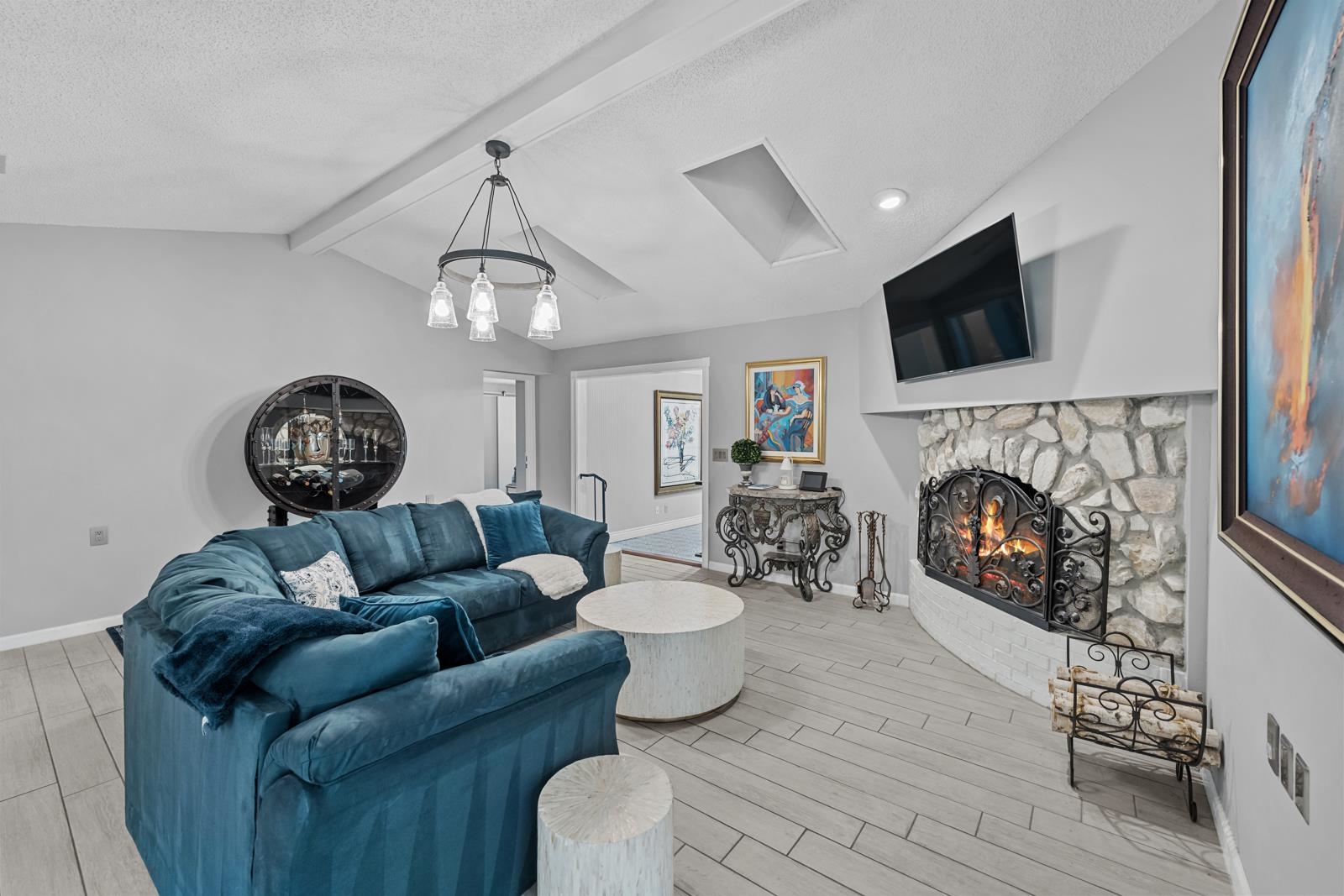 3911 Hillwood Road Jacksonville, FL 32223 - Photo 6 of 33 Living room featuring a fireplace, vaulted ceiling with beams, a chandelier, and light hardwood / wood-style floors